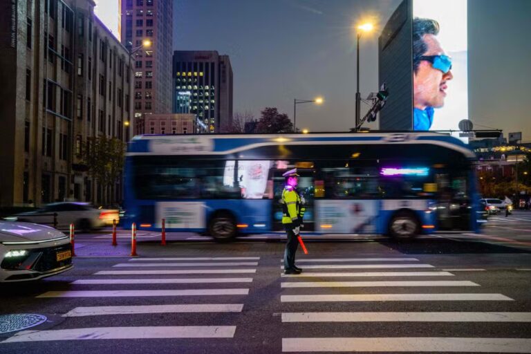 112945341-vehicles-drive-past-a-traffic-policeman-in-the-gwanghwamun-district-of-seoul-on-novemb.jpg