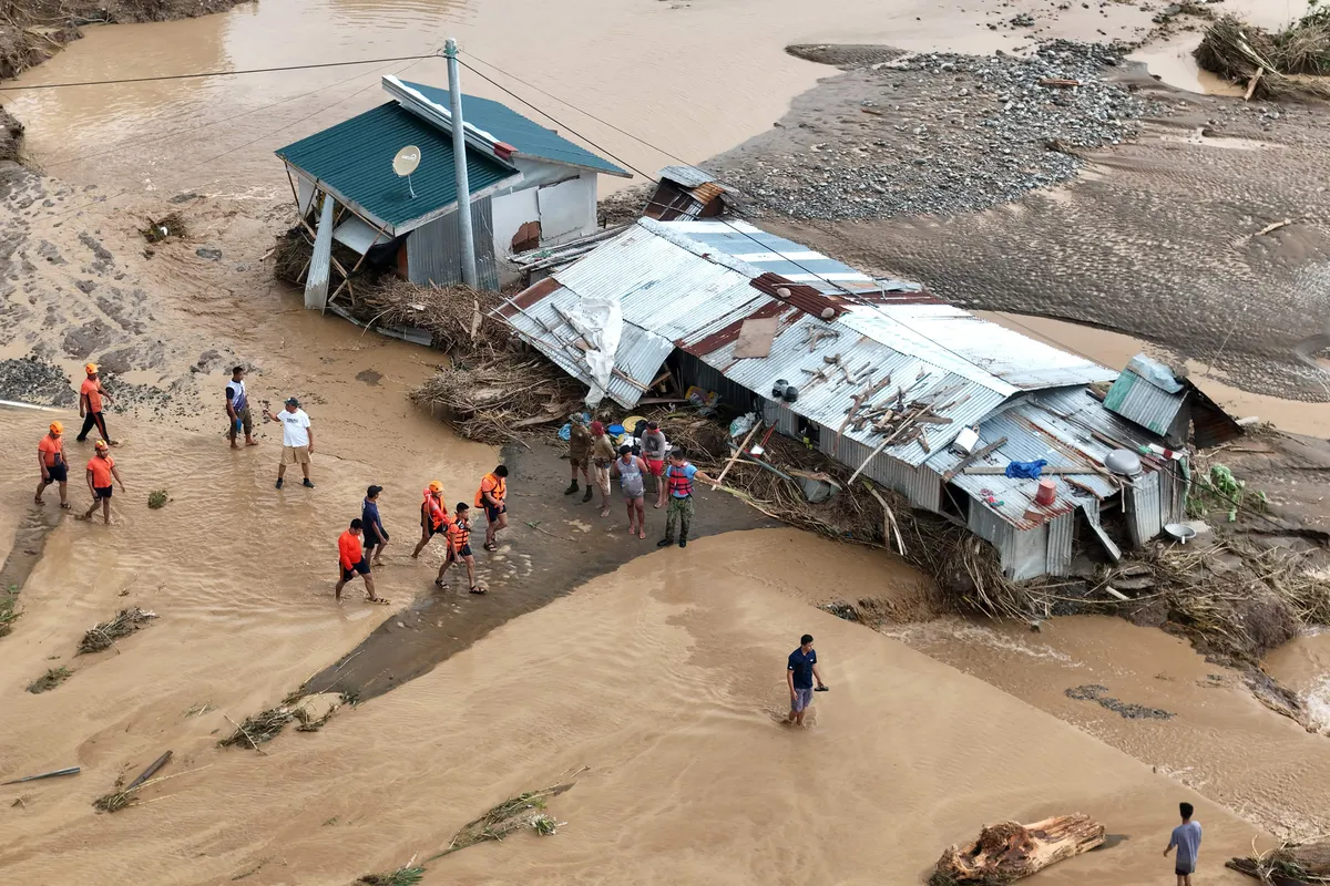 112973803-this-aerial-photo-shows-rescuers-walking-past-flood-hit-houses-at-a-village-in-tuao-town-c.webp