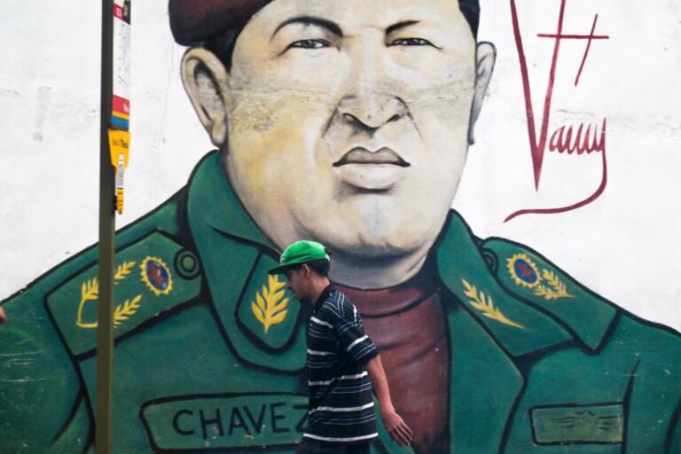 112981295-a-man-walks-past-a-mural-depicting-the-late-venezuelan-president-hugo-chavez-in-caracas-on.avif