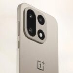 An outdoor scene of tables and sidewalk outside a restaurant, showing a big plant and heat lamps for outside tables.