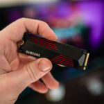 A hand holding the Samsung 990 Pro SSD.